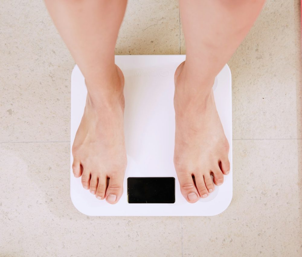 person standing on white digital bathroom scale